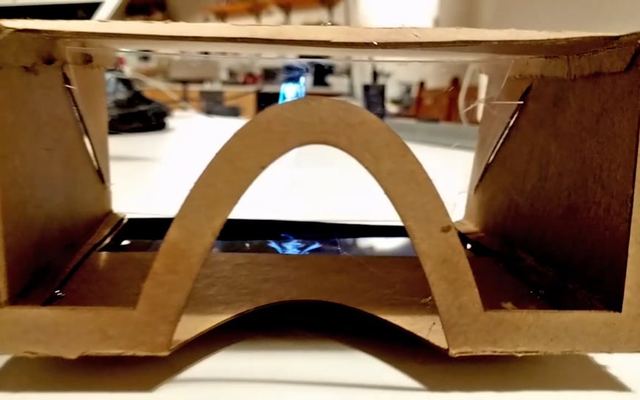 A cardboard headset frame with a phone screen under an angled reflector