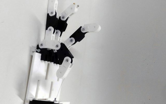 A white robotic hand with servo-driven fingers