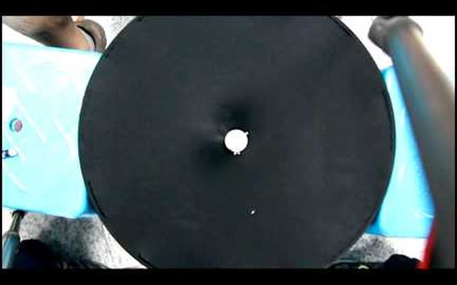 Video still: a ball on a stretched black membrane